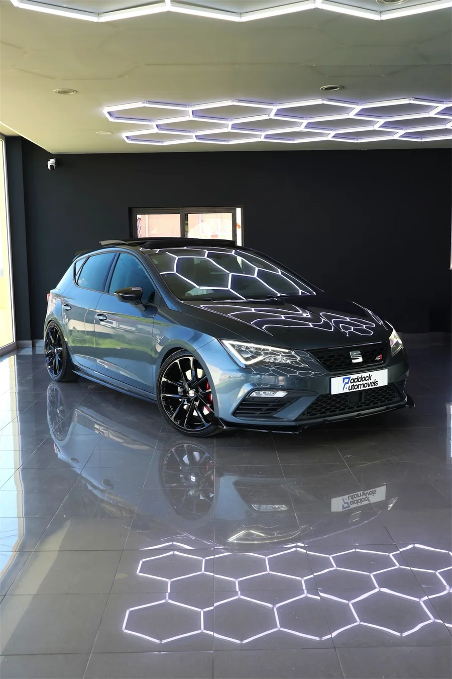 SEAT Leon Cupra 290 DSG cinzento de 2018, visto de frente e de lado no showroom