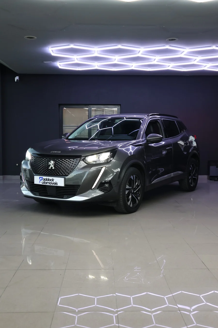 Peugeot 2008 Allure cinzento, visto de frente em ângulo no showroom